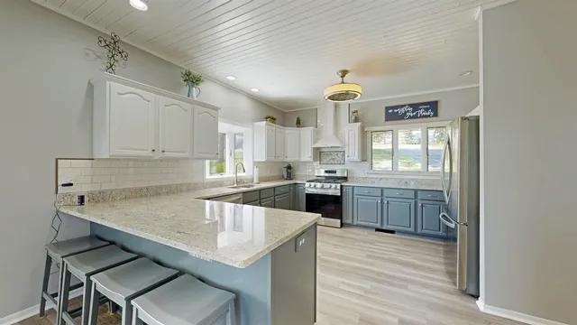 a kitchen with granite countertop a sink cabinets and wooden floor