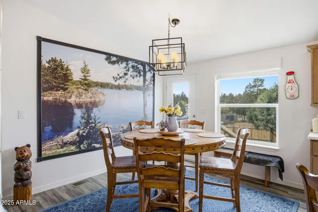 a kitchen with stainless steel appliances kitchen island granite countertop a table chairs and a refrigerator