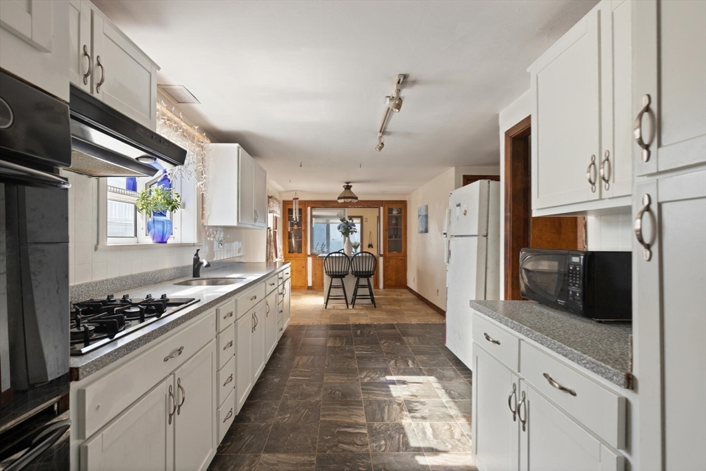 55 Castle Road Nahant, MA 01908 - Photo 7 of 32 a kitchen with stainless steel appliances kitchen island granite countertop a stove and a refrigerator
