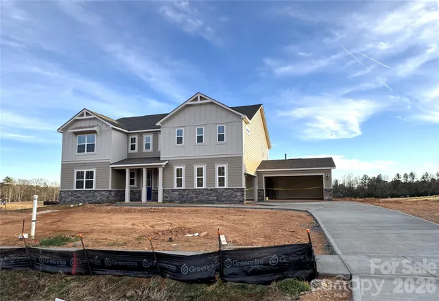 a front view of a house with a garden and yard