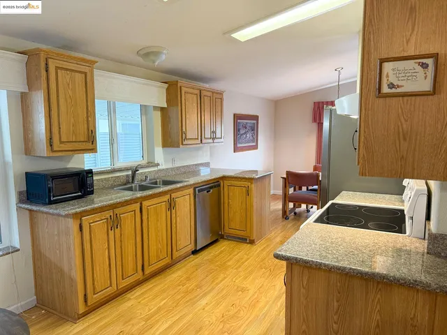 a kitchen with granite countertop a sink stove and cabinets