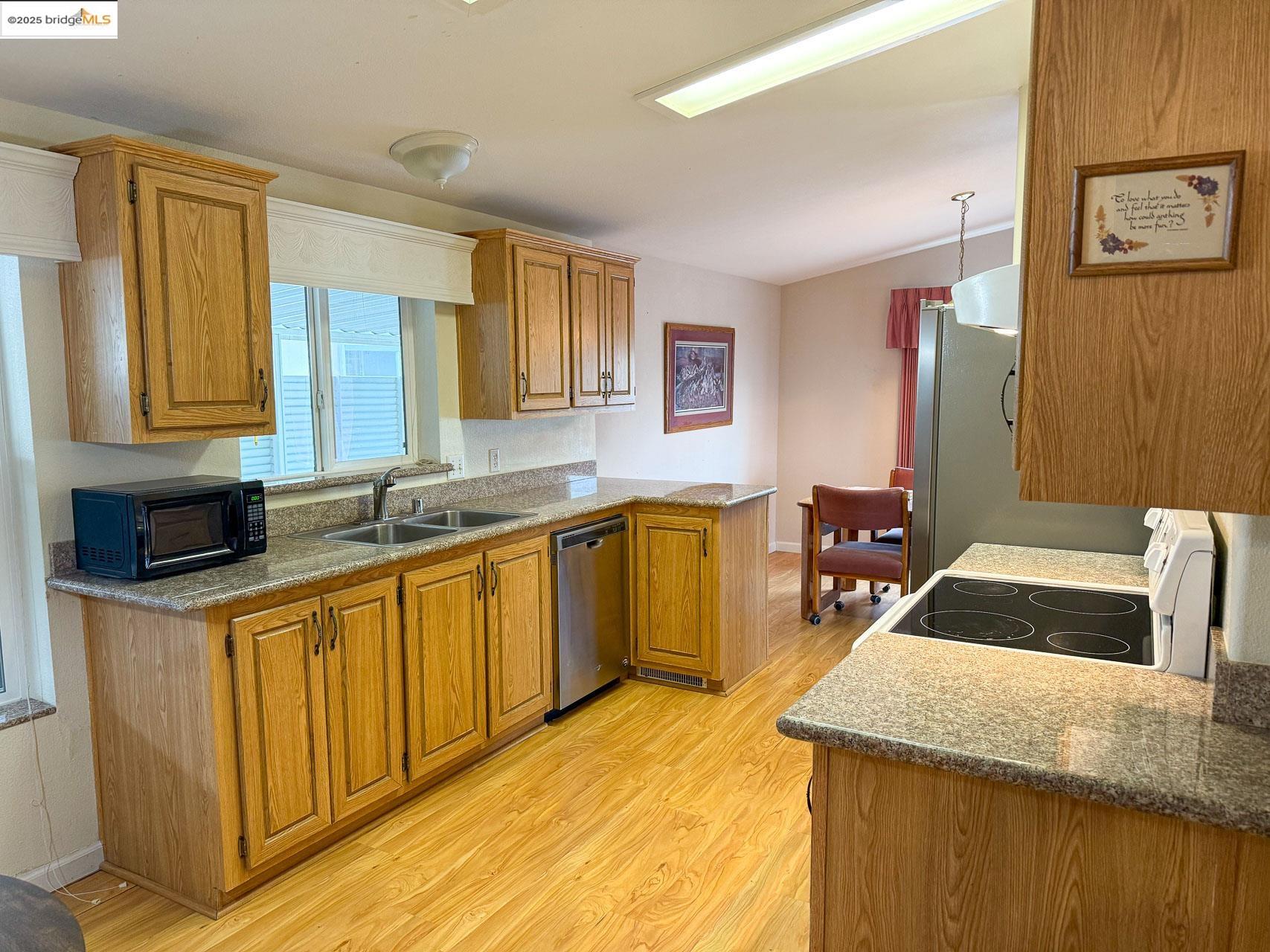 18717 Mill Villa Road, Unit 636 Jamestown, CA 95327 - Photo 12 of 24 a kitchen with granite countertop a sink stove and cabinets