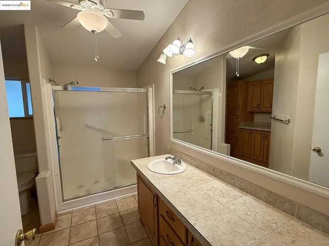 a bathroom with a granite countertop sink a shower and a mirror