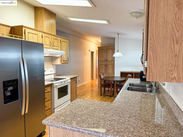 a kitchen with stainless steel appliances granite countertop a sink stove and refrigerator