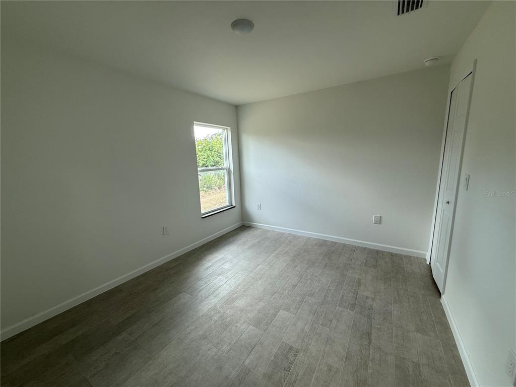 2164 Northland Avenue North Port, FL 34288 - Photo 23 of 31 an empty room with wooden floor and windows