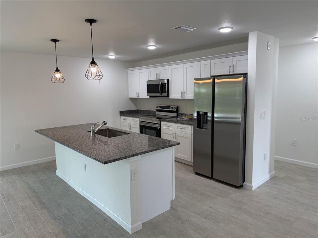 2164 Northland Avenue North Port, FL 34288 - Photo 6 of 31 a kitchen with stainless steel appliances granite countertop a refrigerator a sink a stove a microwave and island