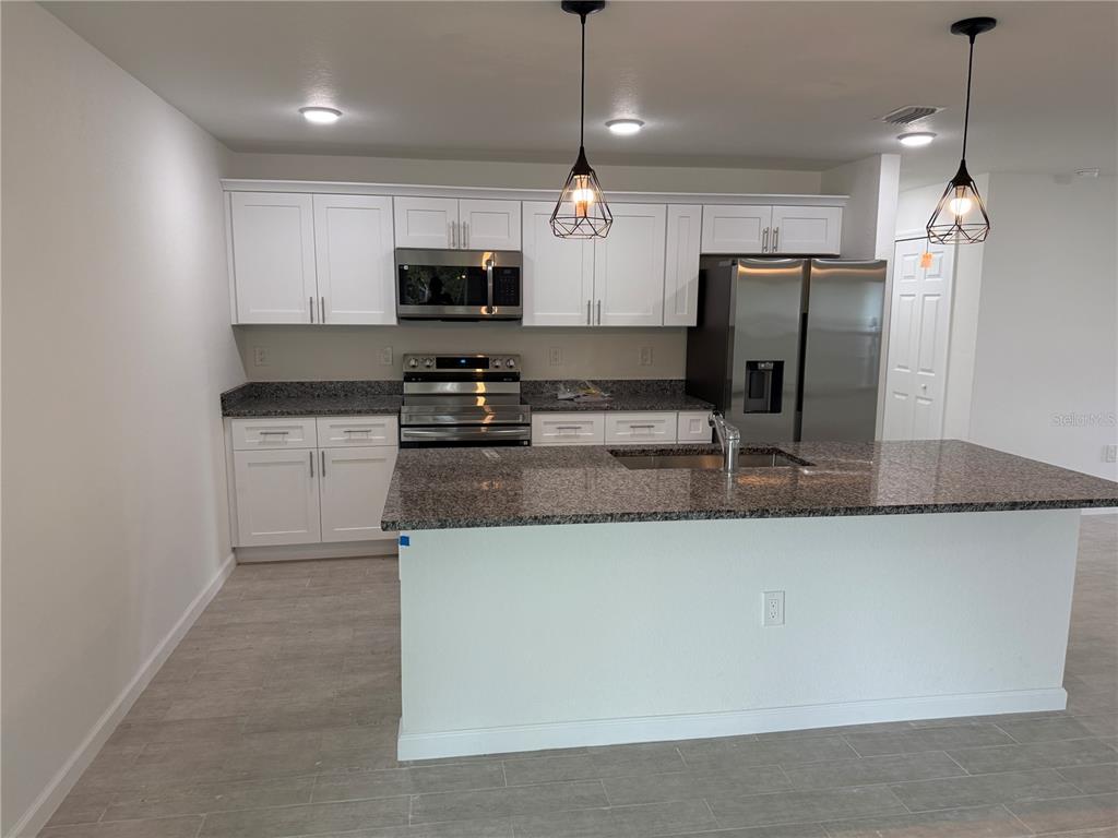 2164 Northland Avenue North Port, FL 34288 - Photo 7 of 31 a kitchen with stainless steel appliances granite countertop a sink a stove a refrigerator a center island with wooden floor