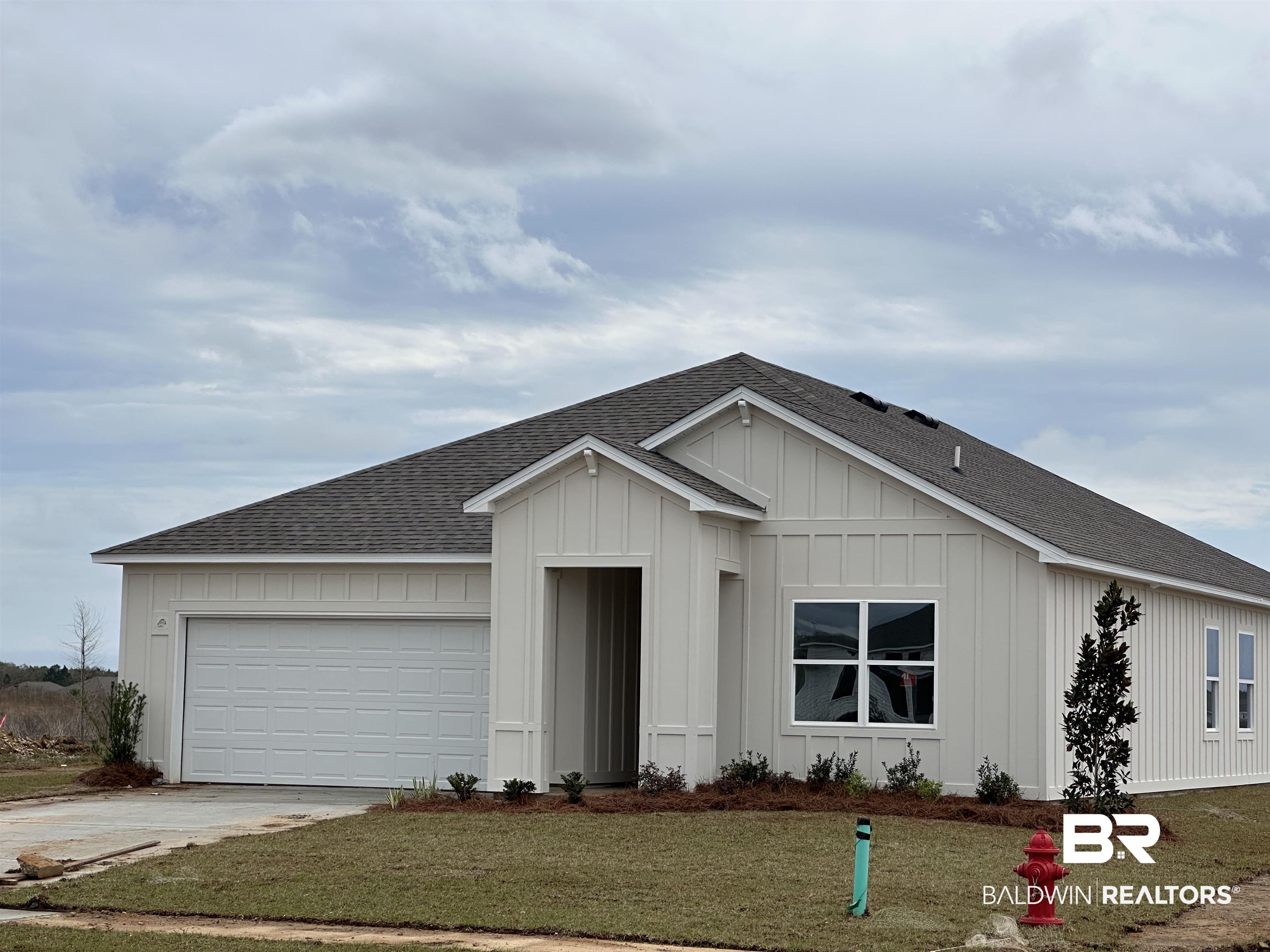 18104 Kent Circle Foley, AL 36535 - Photo 2 of 2 View of front of home with a shingled roof, board and batten siding, a front lawn, driveway, and an attached garage