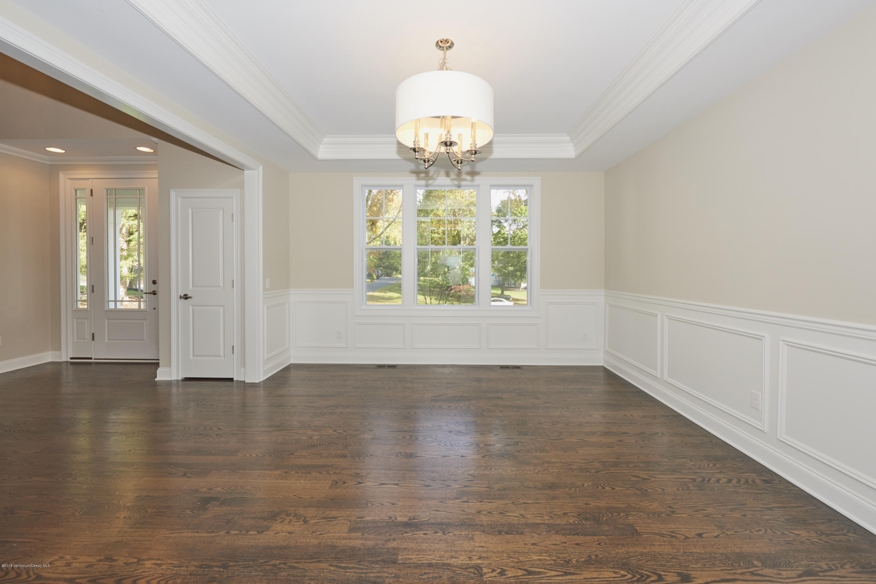 17 Cardinal Road Middletown, NJ 07748 - Photo 5 of 22 an empty room with wooden floor chandelier and windows