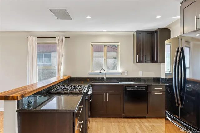 a kitchen with stainless steel appliances granite countertop a sink stove and refrigerator