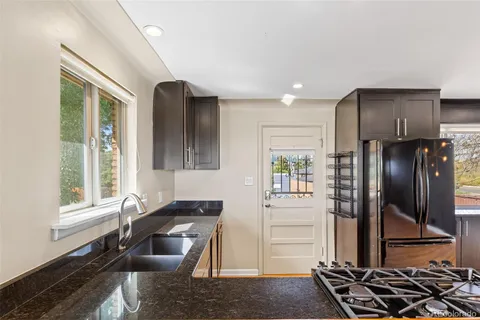 a kitchen with stainless steel appliances granite countertop a refrigerator and a stove