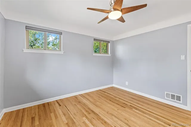 a view of empty room with wooden floor