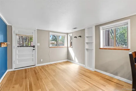 a view of empty room with wooden floor and fan