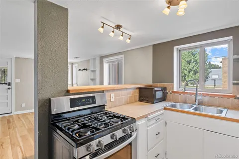 a kitchen with a stove a sink and a window