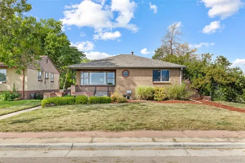 a front view of a house with a yard and trees