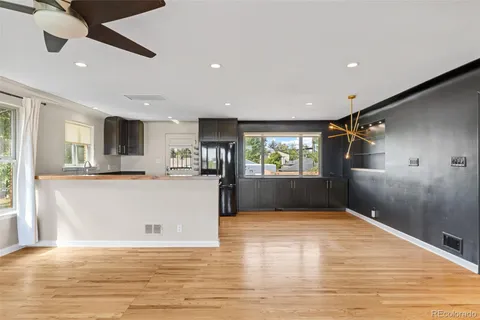 a view of kitchen and empty room with wooden floor