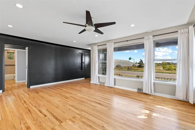 a view of empty room with wooden floor and windows