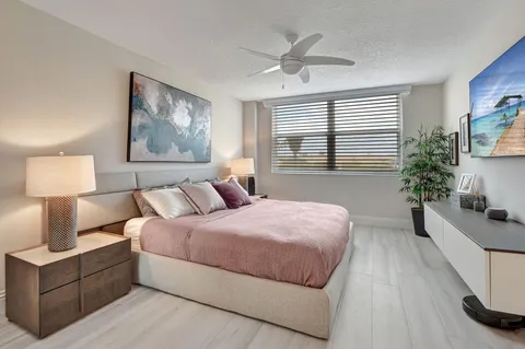 a spacious bedroom with a bed and a chandelier