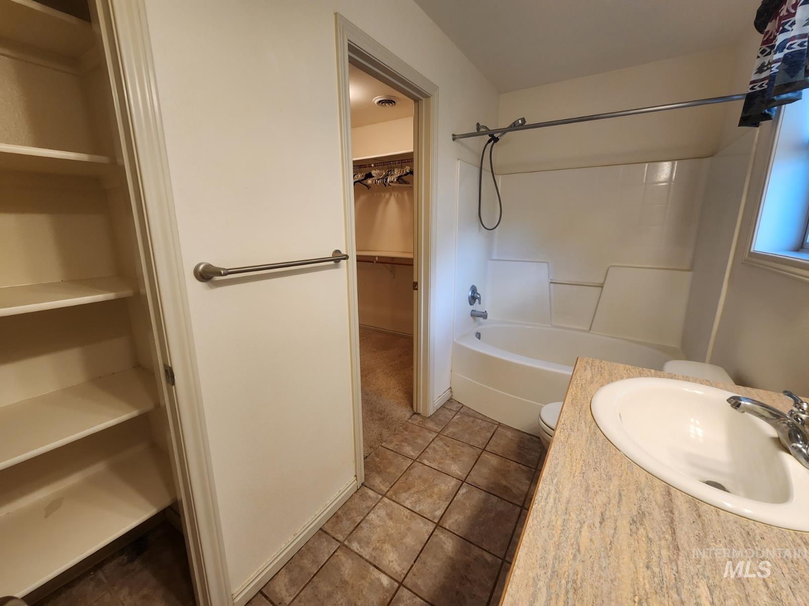 1000 North Rodeo Street Parma, ID 83660 - Photo 15 of 35 Full bath with a spacious closet, vanity, shower / tub combination, and light tile patterned floors