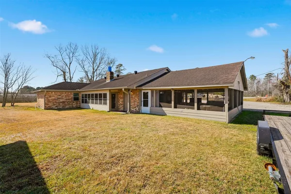 a front view of house with yard and trees in the background