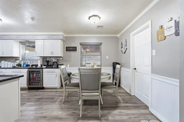 a kitchen with a table chairs refrigerator and microwave