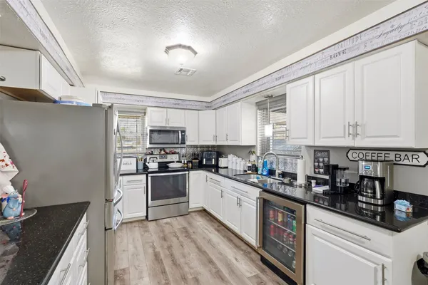 a kitchen with stainless steel appliances granite countertop a stove a sink dishwasher and a refrigerator
