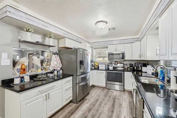 a kitchen with granite countertop stainless steel appliances and wooden cabinets