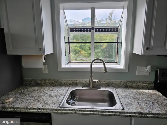 a kitchen with granite countertop a sink and a window