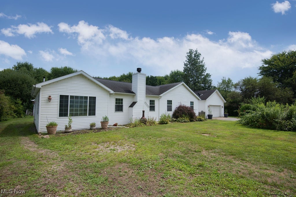 4594 Center Road Andover, OH 44003 - Photo 2 of 39 Front view of property with a chimney, a lawn, and a garage