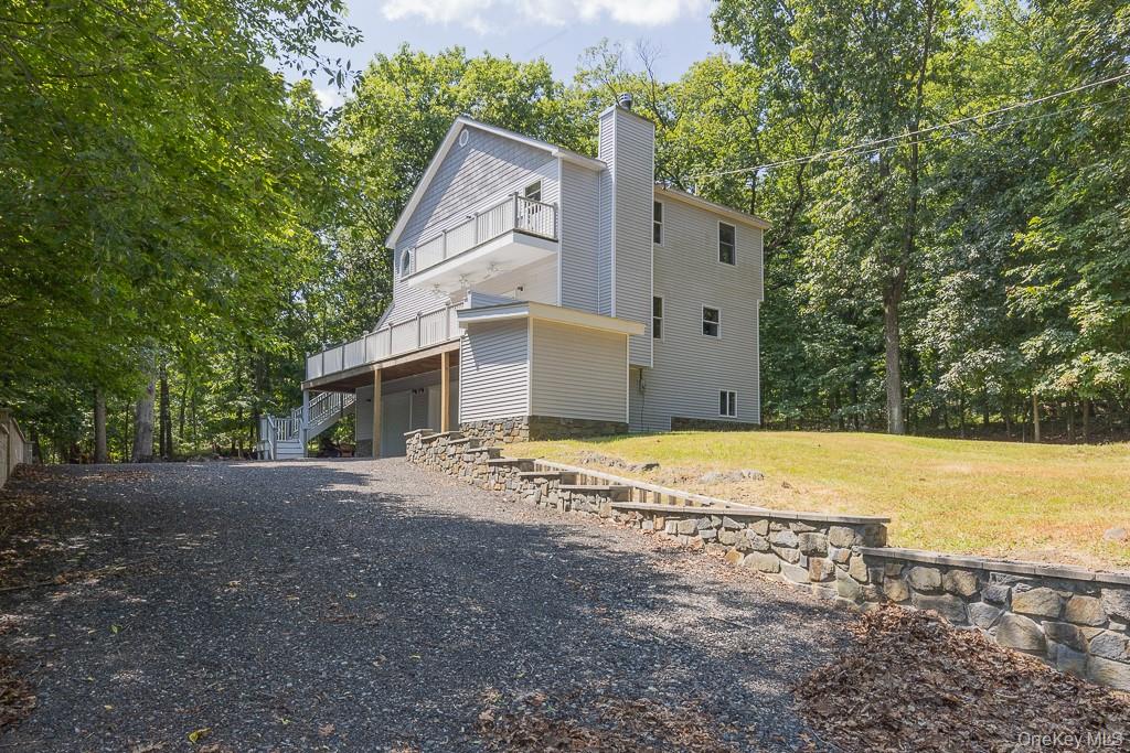 a view of a house with backyard and trees