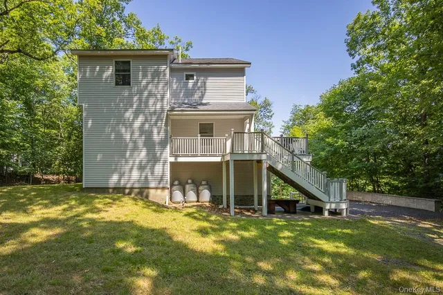a view of a house with pool and chairs next to a yard
