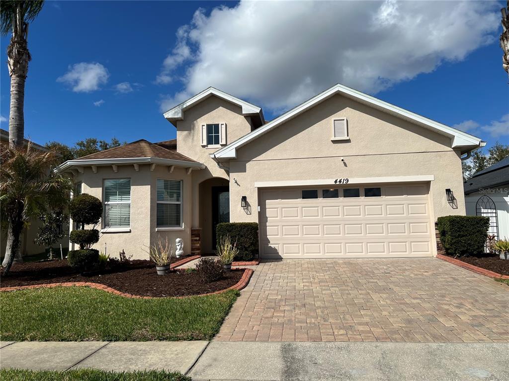 4419 Azure Isle Way Kissimmee, FL 34744 - Photo 1 of 39 a front view of a house with a yard and garage
