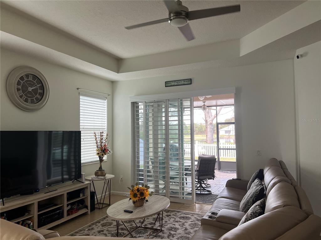 4419 Azure Isle Way Kissimmee, FL 34744 - Photo 15 of 39 a living room with furniture a flat screen tv and a window