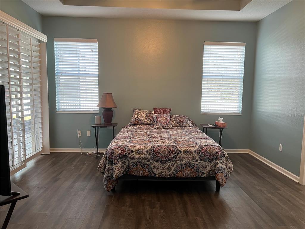4419 Azure Isle Way Kissimmee, FL 34744 - Photo 16 of 39 a bedroom with a bed a window with wooden floor