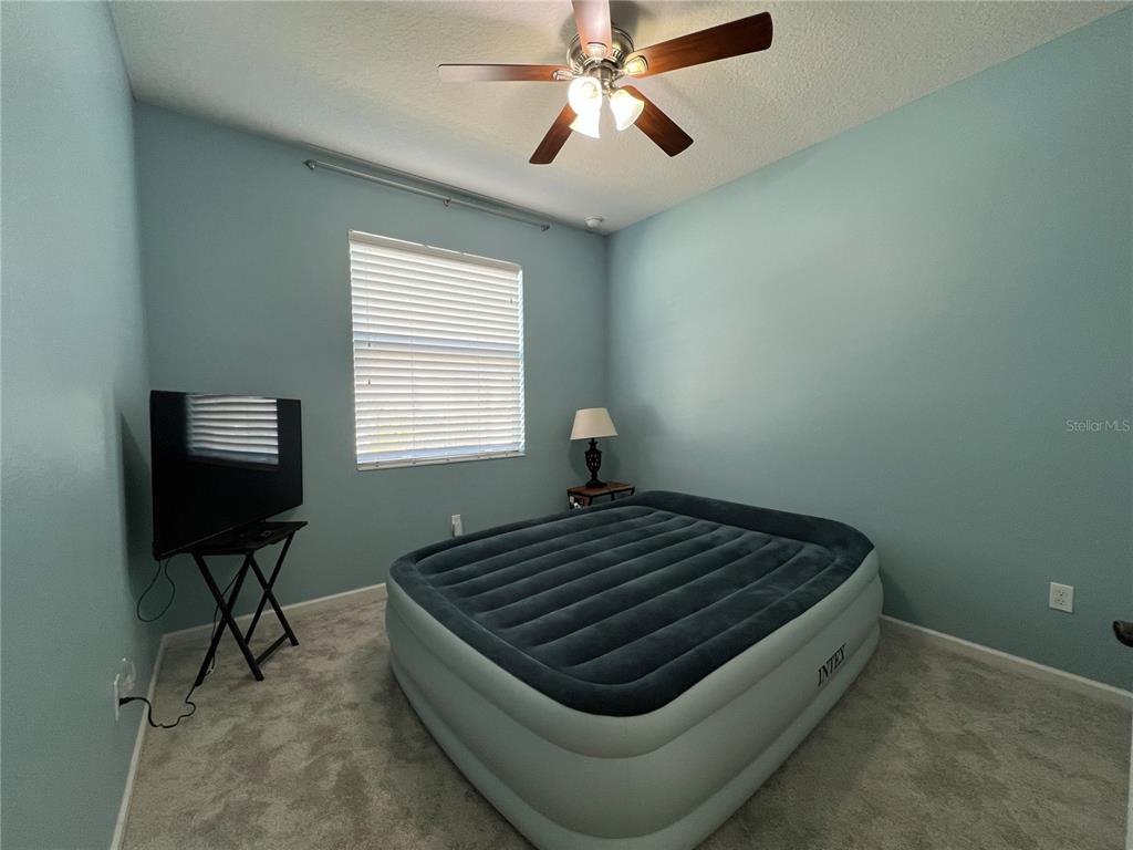 4419 Azure Isle Way Kissimmee, FL 34744 - Photo 24 of 39 a bedroom with a bed and a chandelier