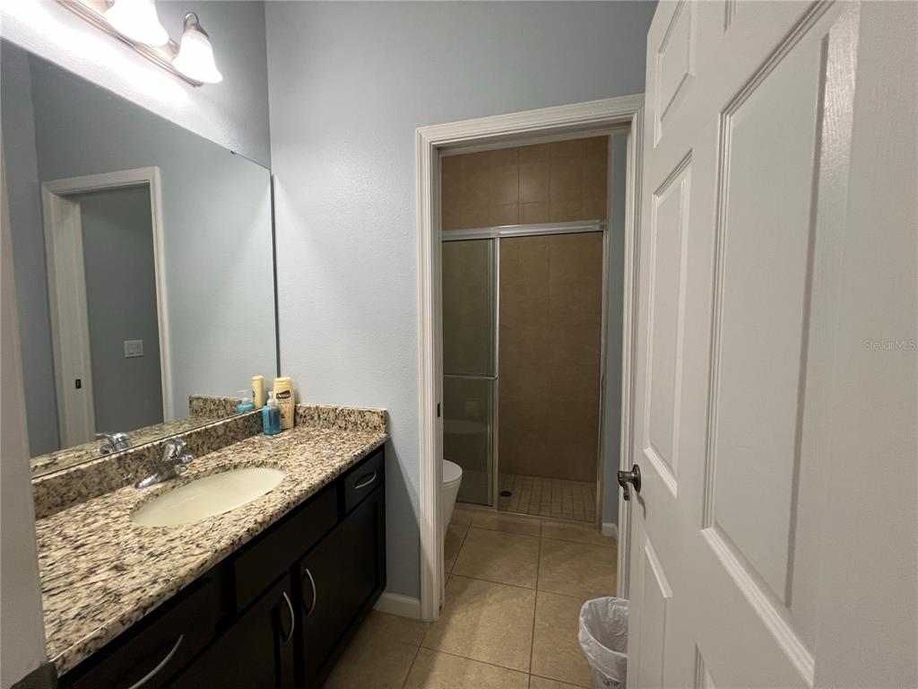 4419 Azure Isle Way Kissimmee, FL 34744 - Photo 25 of 39 a bathroom with a granite countertop sink and a mirror