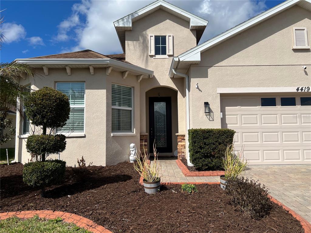 4419 Azure Isle Way Kissimmee, FL 34744 - Photo 3 of 39 a front view of a house with a yard
