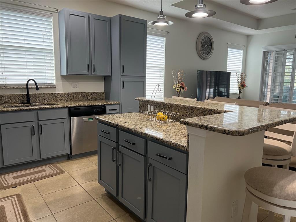 4419 Azure Isle Way Kissimmee, FL 34744 - Photo 10 of 39 a kitchen with granite countertop a sink and a stove