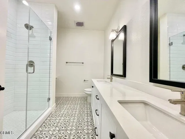 a bathroom with a shower sink and mirror