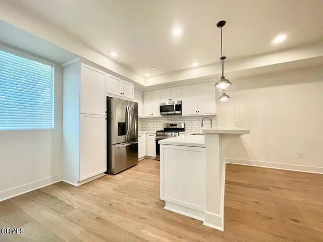 a kitchen with a sink stainless steel appliances and cabinets