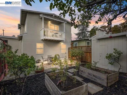 a view of a yard with plants and a barbeque