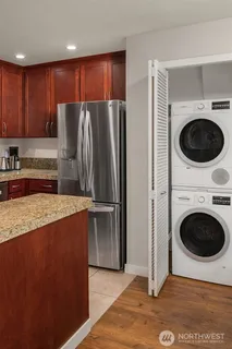 a kitchen with granite countertop a refrigerator and a stove top oven