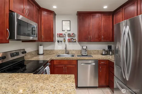 a kitchen with stainless steel appliances granite countertop a sink stove and refrigerator