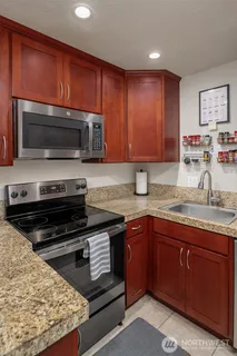 a kitchen with granite countertop wooden cabinets and stainless steel appliances