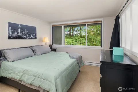 a large bed sitting in a bedroom next to a window