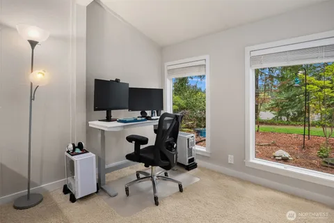 a view of a workspace with furniture and a window