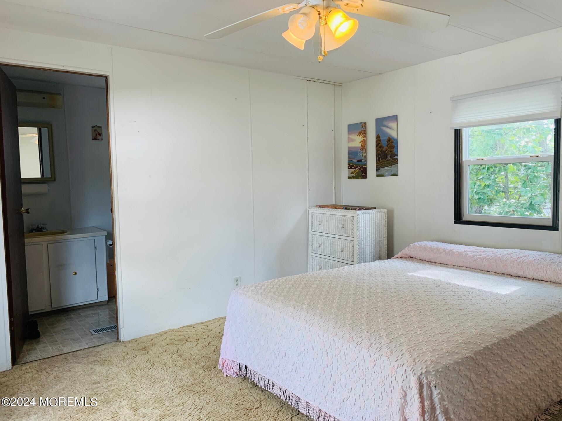 31 Panda Lane Whiting, NJ 08759 - Photo 14 of 16 a bedroom with a bed and a chandelier