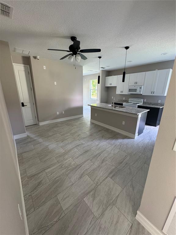 5238 2nd Street Orlando, FL 32810 - Photo 14 of 19 a large kitchen with kitchen island a stove a sink a refrigerator wooden floor and cabinets