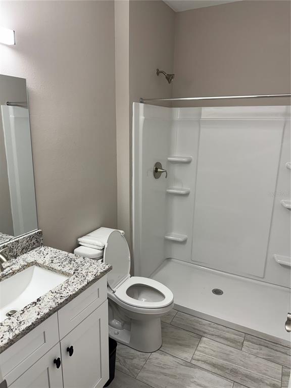 5238 2nd Street Orlando, FL 32810 - Photo 7 of 19 a bathroom with a granite countertop sink a toilet a mirror and shower