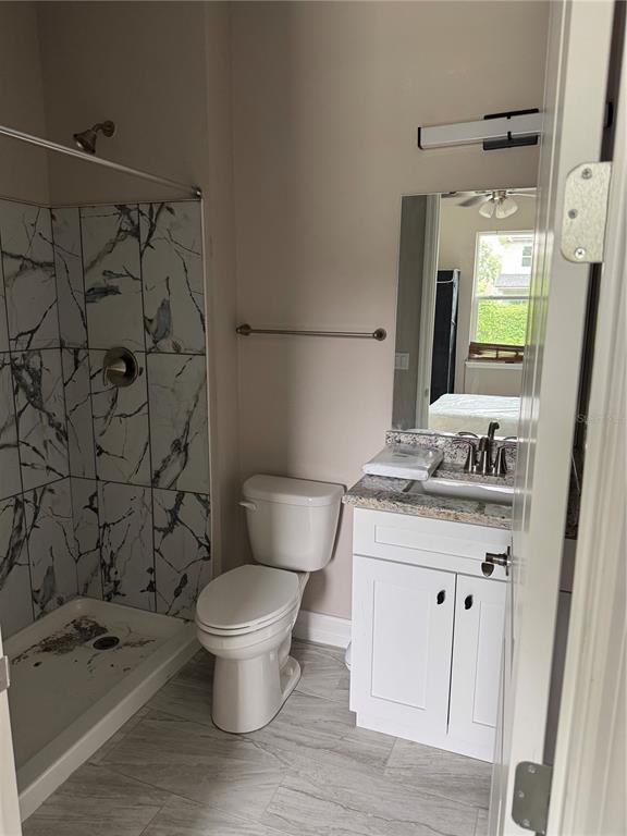 5238 2nd Street Orlando, FL 32810 - Photo 8 of 19 a bathroom with a granite countertop sink a toilet and a mirror